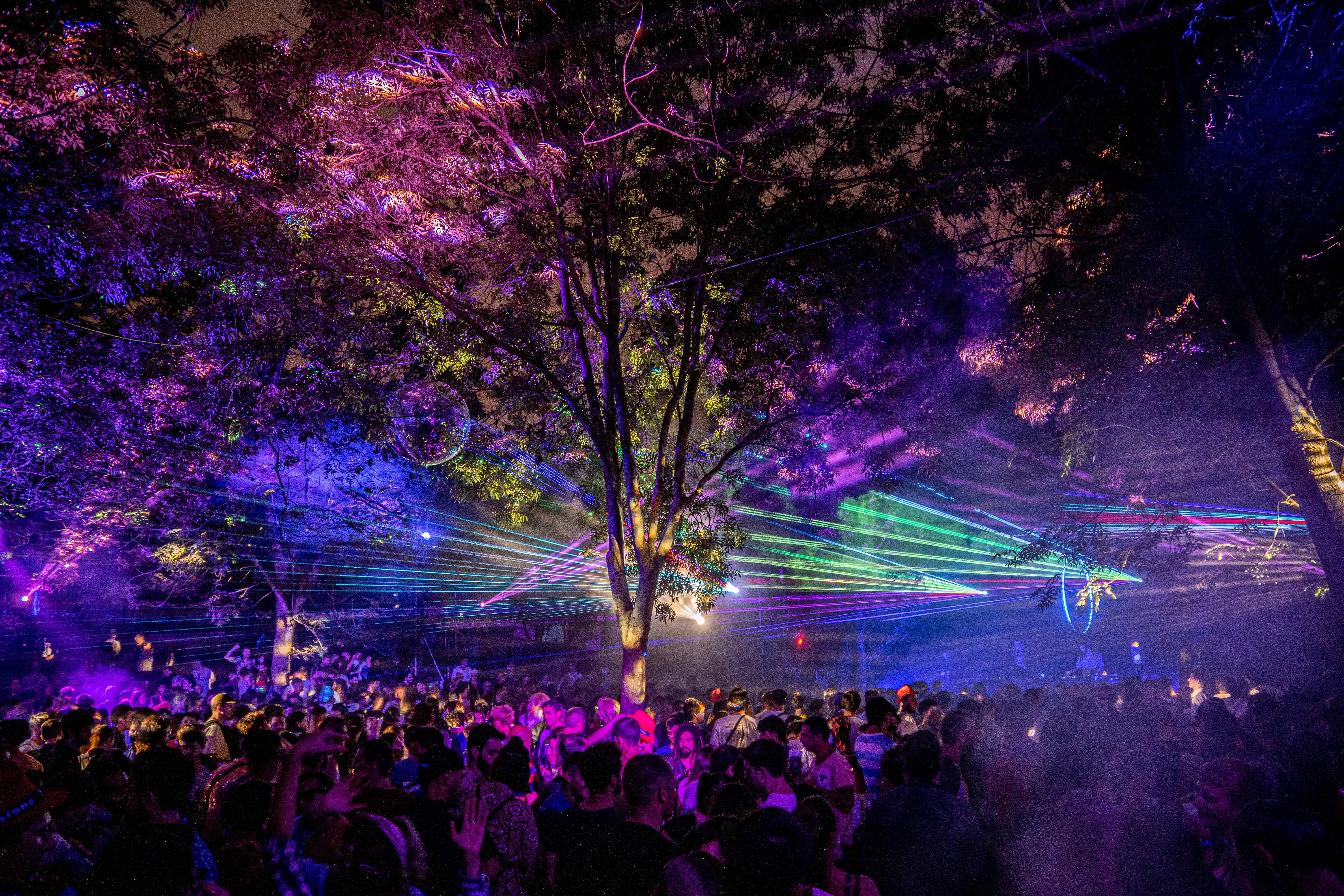 A laser light show takes place over the heads of a crowd dancing to a night-time electronic music set at Bilbao BKK Live festival.