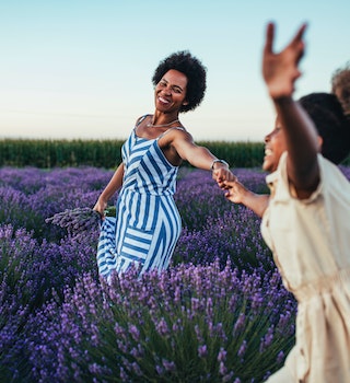 Afro mother and her daughter bonding together outdoors at the lavender field