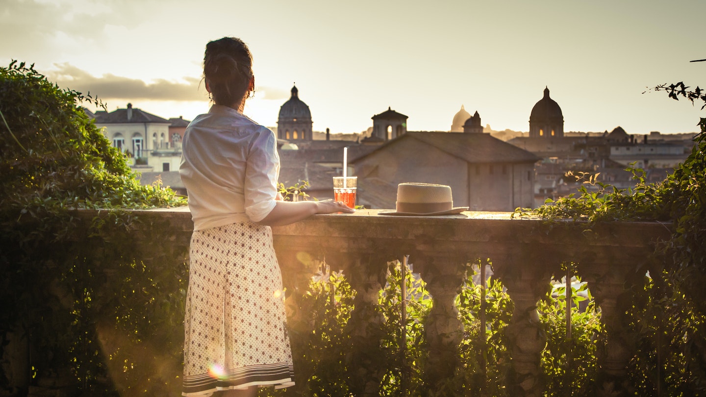 Young woman tourist fashion white dress with spritz cocktail in front of panoramic view of Rome cityscape from campidoglio terrace at sunset. Landmarks, domes of Rome, Italy.
1207032121
