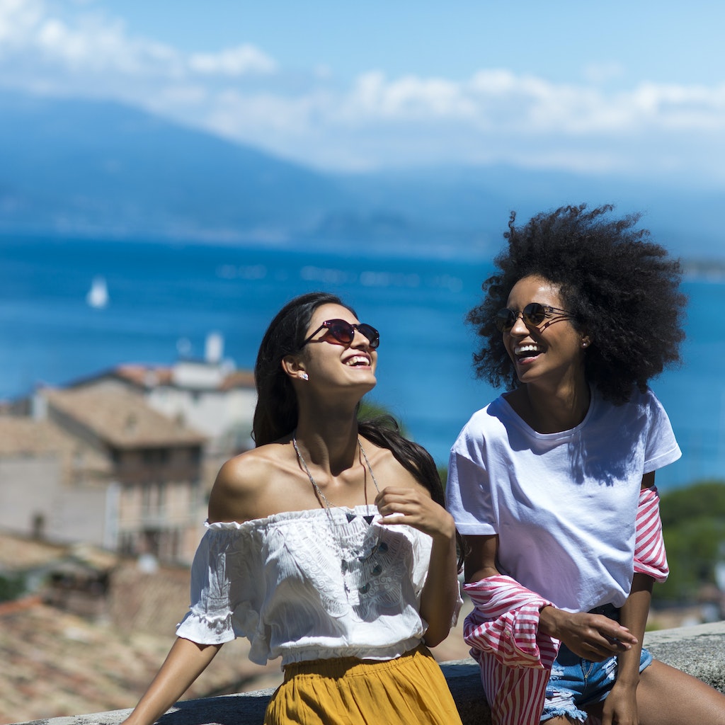 Horizontal picture of two girl friends laughing by the sea side
909521922
Two women laughing together on hilltop overlooking the coast in Italy
