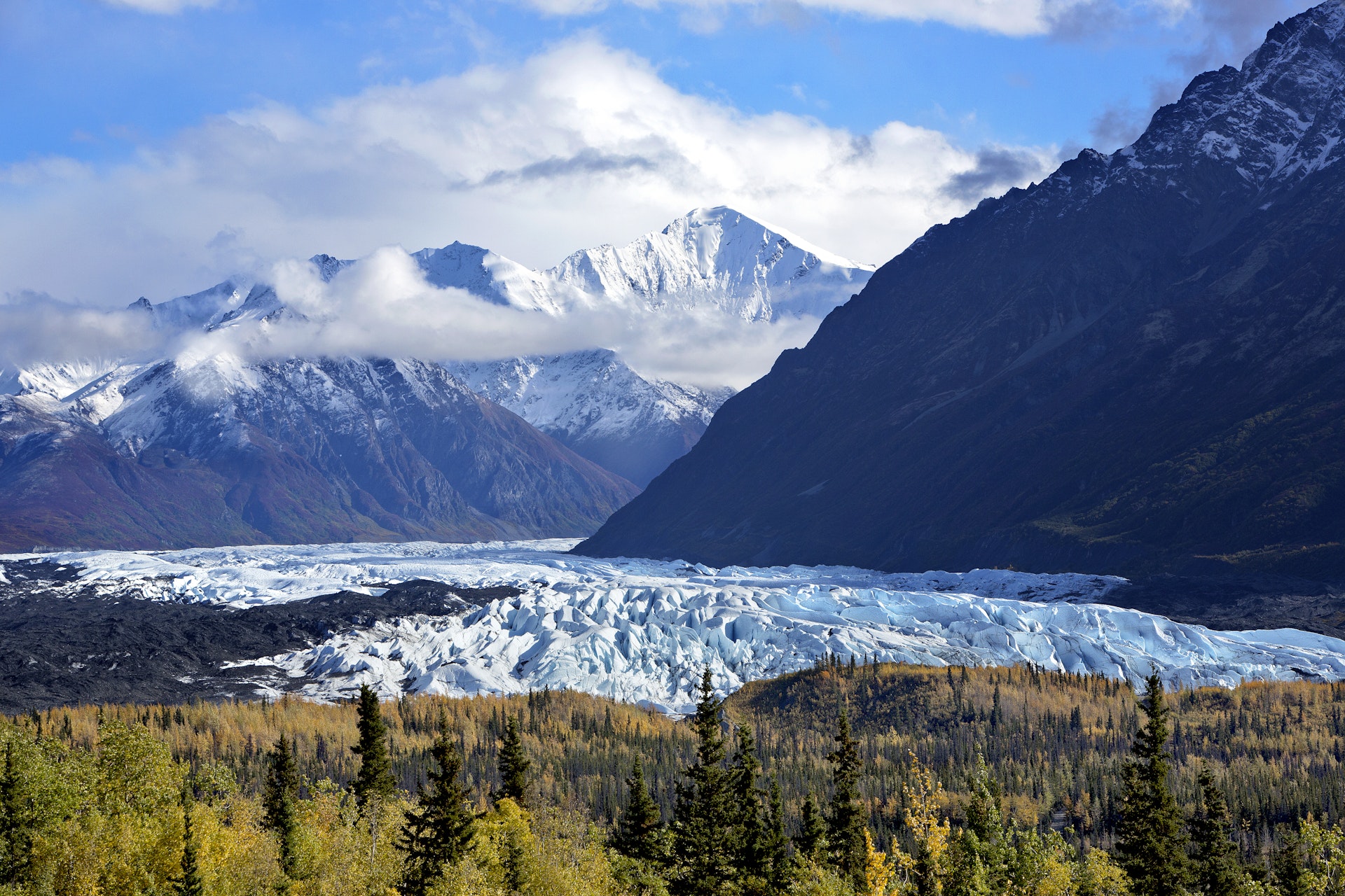 A landscape of a large glacier framed by mountain peaks