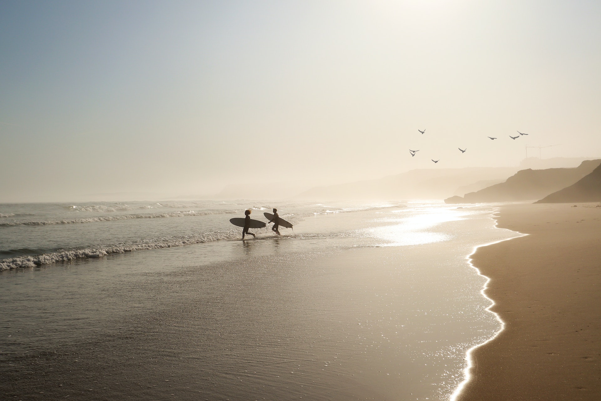 Surfers on the beach at Praia Lagide, Portugal