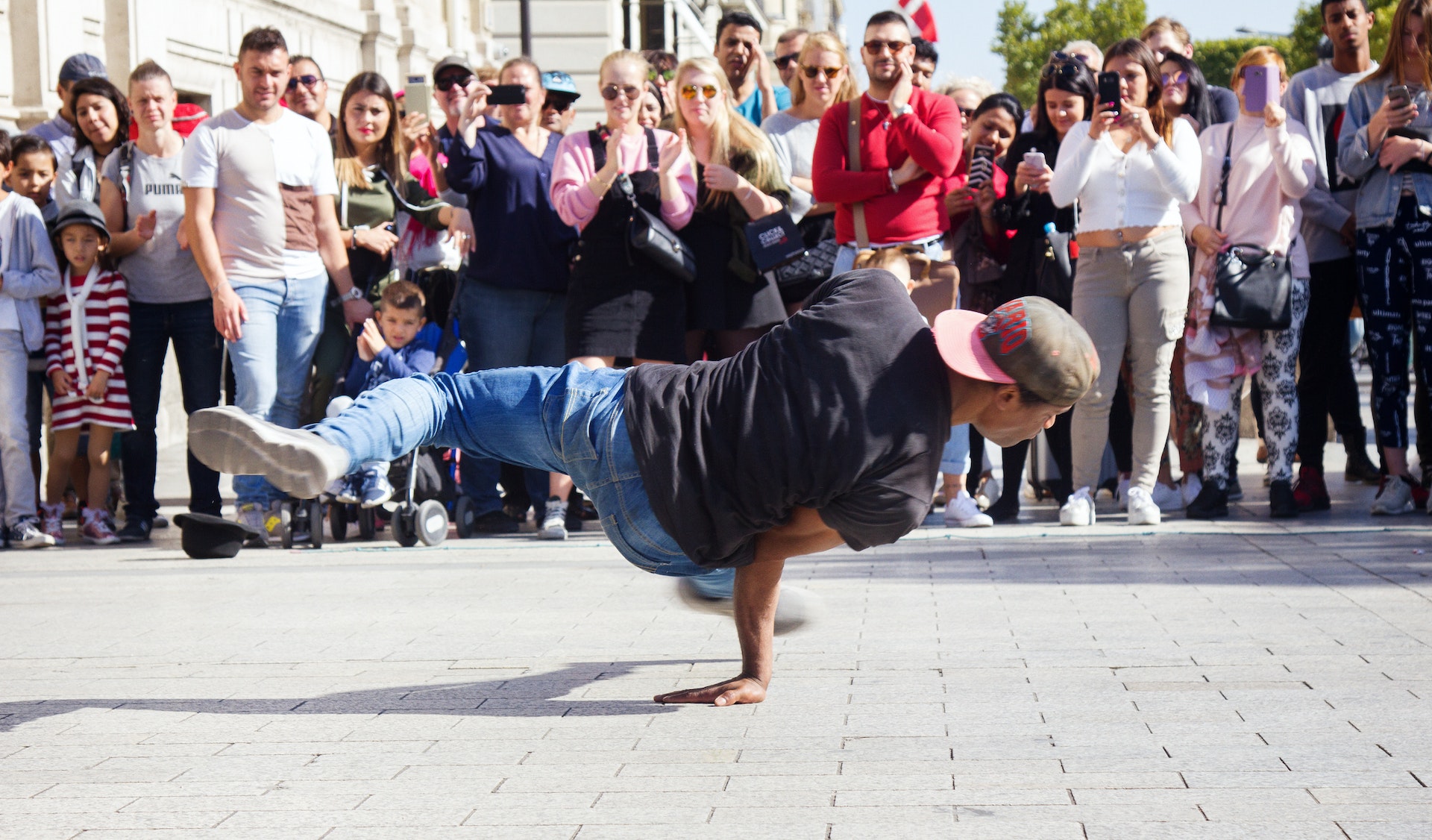 A break dancer performing in front of a crowd in the streets of Paris