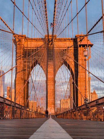 Visitors crossing the Brooklyn bridge during the early morning.