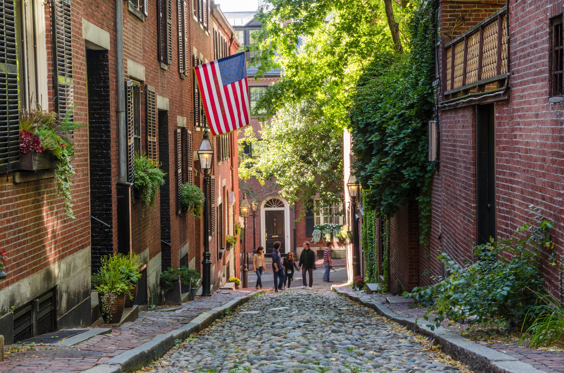 Tourists wandering along Acorn Street in Beacon Hill on a warm autumn day.
