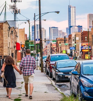 A couple holds hands while they go for a walk in the West Town neighborhood. West Town is popular because of city views and easy access to downtown Chicago.